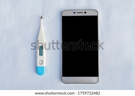 Digital thermometer with mobile phone on white background