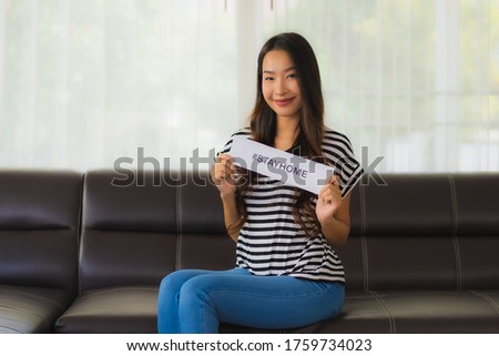Portrait beautiful young show paper stay home on sofa in livingroom for save people from coronavirus or covid19 Royalty-Free Stock Photo #1759734023