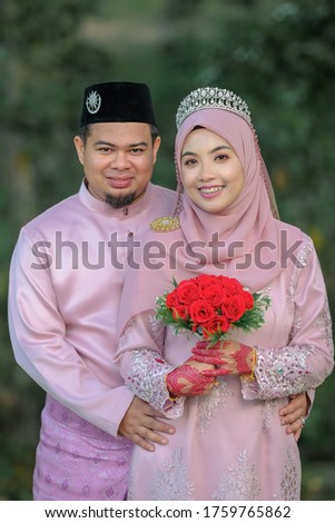 Outdoor shooting for Malay wedding, the bride and groom wearing Malay traditional cloth with  beautiful scenery.