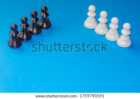 Black and white chess pieces on a blue background. Stop racism. Black lives matter! Motivational poster against racism and discrimination. international chess day.