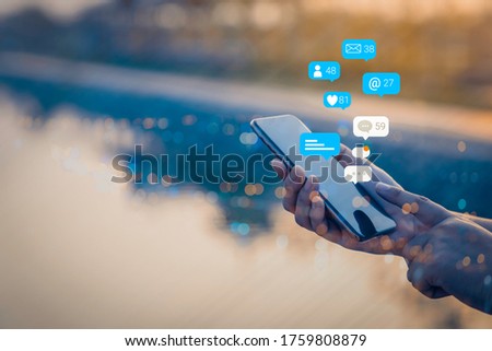 Person using a social media marketing concept on mobile phone with notification icons of like, message, comment and star above smartphone screen. Royalty-Free Stock Photo #1759808879