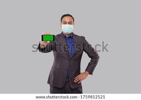 Businessman Showing Phone Holding Horizontal Wearing Medical Mask. Indian Business Man Technology Business at Home. Phone Green Screen Isolated