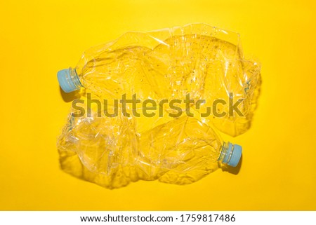 Used plastic bottles for recycling, on a yellow background, conceptual image with copy space