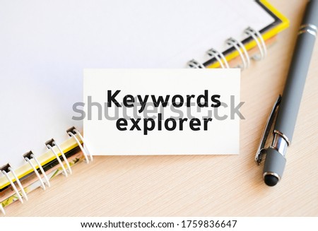 Keywords explorer - text on a notebook with a spring and a gray pen