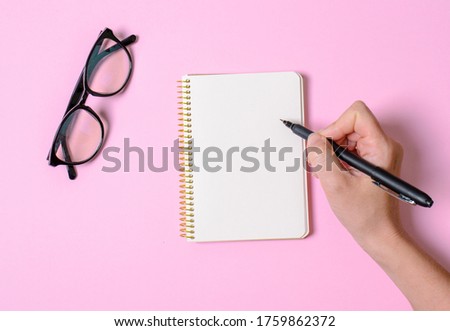 Notebook with slip sheets, hand with handle, office glasses. A place for text. Trends 2020