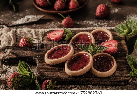 Delicious crispy tartlets with fresh strowberries jam and mint