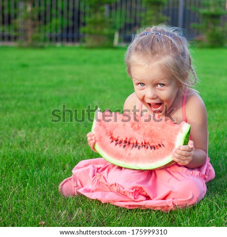 Little adorable funny girl with a piece of watermelon in hands