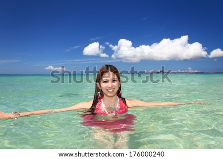 Young Asian woman on the beach enjoy sunlight 