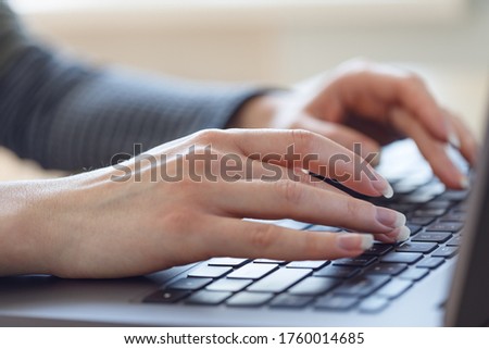 Woman is typing on a laptop. Hands close up.