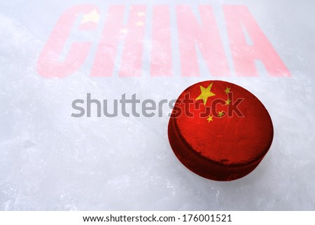 Vintage old hockey puck with the China flag is on the ice