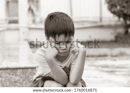 Sepia tone. 5​-6​ years​ old​ child.​ Alone​ Asian​ little​ boy​ feel​ sad, angry​ and​ stressed.​ He​ lonely at​ the​ playground.​ Unhappy kid.​ Mood and​ emotions.