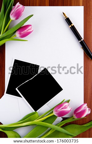 Blank photos, letters, pen and pink tulips 
