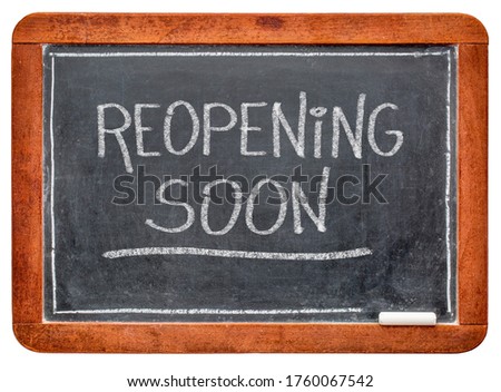 reopening soon - white chalk handwriting on a slate blackboard, business opening after coronavirus covid-19 pandemic and social distancing