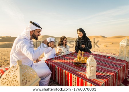 Arabian family with kids having fun in the desert - Parents and children celebrating holiday in the Dubai desrt Royalty-Free Stock Photo #1760078081