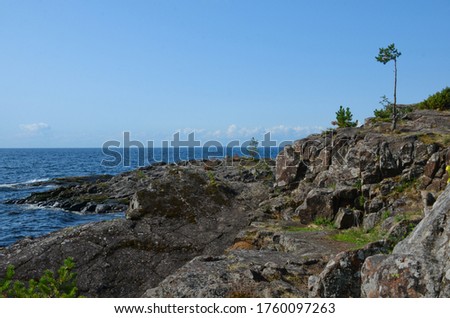 The rocky shore of Lake Ladoga in Karelia on a clear sunny day. Beautiful nature, horizontal photo