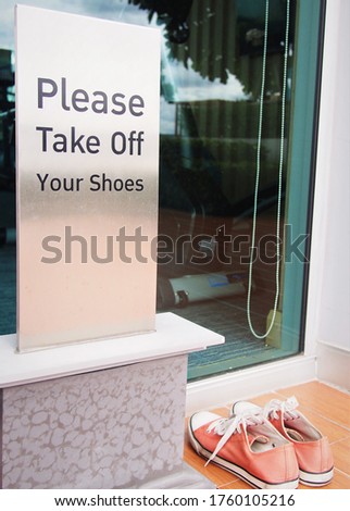 take off your shoes sign in front of the room