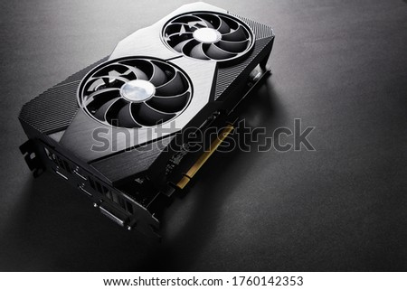 modern black computer video card on a black background, deep shadows and contrasting light, one object close view, electronic device or computer part