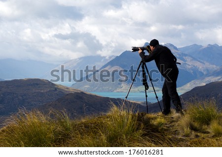 Authentic professional travel photographer content creator photographing the dramatic landscape view of New Zealand South Island alpine destination outdoors near Queenstown. Real people. Copy space