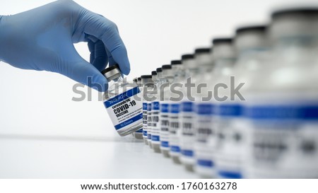 Covid-19 Corona Virus 2019-ncov vaccine vials medicine drug bottles syringe injection blue nitrile surgical gloves. Vaccination, immunization, treatment to cure Covid 19 Corona Virus infection Concept Royalty-Free Stock Photo #1760163278