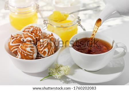A Cup of hot black tea with cookies and honey on a white background, the filling process . Selective focus