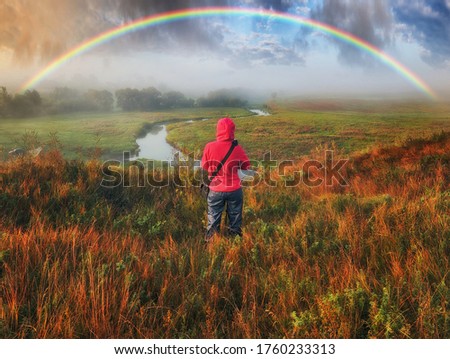 Woman Looking At Rainbow. rainbow over the autumn river
