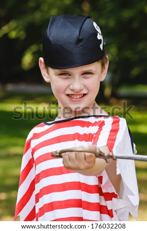 A boy dressed as a pirate holding a toy sword.