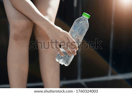A plastic water bottle in a woman's hand