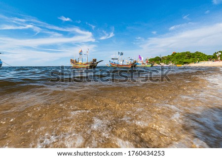 Fishing boat on the sea wave beach with blue sky background in Thailand