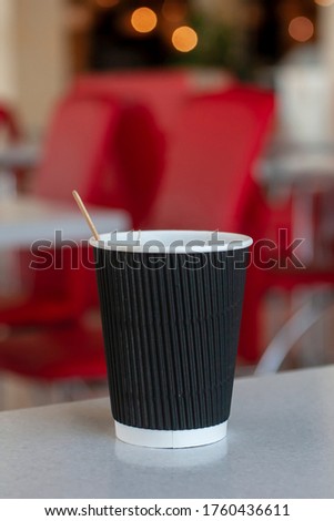 Cheap tea in a cardboard cup in a cafe. Vertical photo.