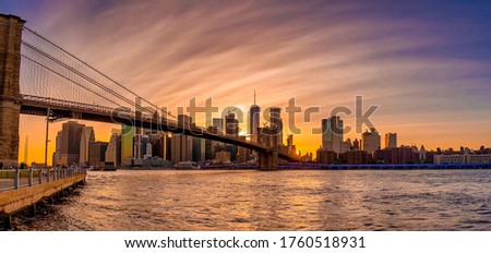 Magical evening sunset view of the Brooklyn bridge from the Brooklyn park with a lower Manhattan view on the other side of the Hudson river.