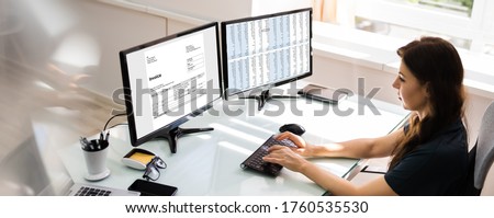 Accountant Using E Invoice Software At Computer In Office Royalty-Free Stock Photo #1760535530