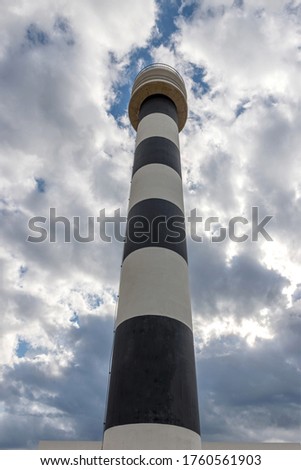 Lighthouse on a background of the morning sky in the clouds.
