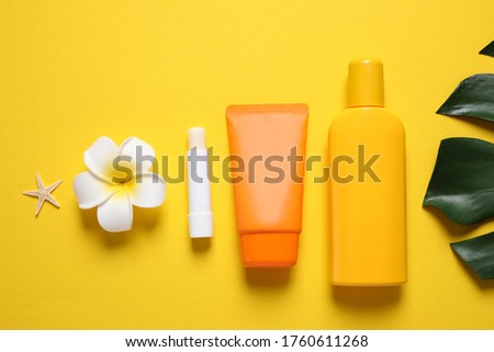 Flat lay composition with sun protection products on yellow background