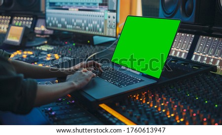 Female Artist, Musician, Producer, Audio Engineer Working in Music Record Studio on a New Album, Use Green Screen Laptop Computer, Control Desk for Mixing and Creating Hit Song