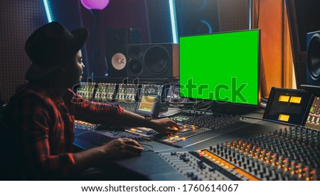 Stylish Audio Engineer / Producer Working in Music Record Studio, Uses Green Screen Computer, Mixer Board Equalizer to Create New Hit Track and Song. Creative Black Artist Musician. Side View Portrait