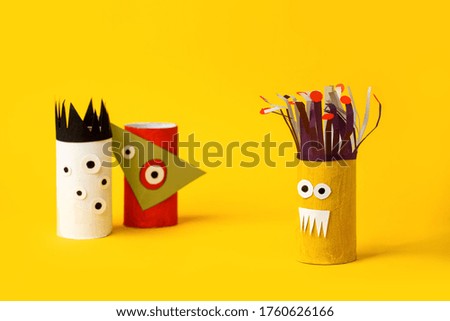 Antistress art therapy for kids, coronavirus pandemic, monsters for Halloween party. Easy crafts for kids on yellow background, copy space, diy creative idea from toilet tube, recycle concept