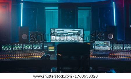 Shot of a Modern Music Record Studio Control Desk with Computer Screen show User Interface of DAW Software with Song Playing. Equalizer, Mixer and other Professional Equipment. Royalty-Free Stock Photo #1760638328