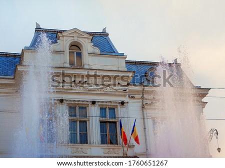 Pitesti City Hall facade in Romania . Fountain splashing in front of the building  Royalty-Free Stock Photo #1760651267