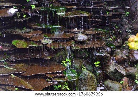 Water flows from a wall of stone piles