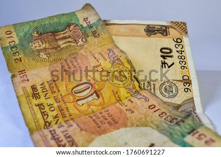 Old 10 rupees Indian currency note and new 10 rupees currency notes kept together on white background.