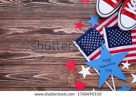Text Happy Independence Day with flag and shoes on wooden background