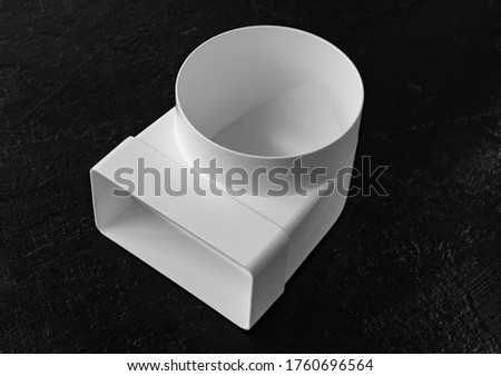 Plastic elbow for flat and round ducts. a part for assembling ventilation, air duct or hood in the kitchen. Black background
