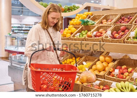 Young woman with blond hair shopping groceries at the supermarket
