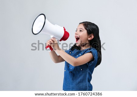 Indian Girl Kid with megaphone shouting on white banner background with copy space Royalty-Free Stock Photo #1760724386