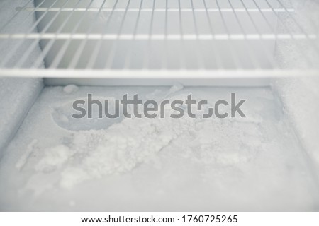 Ice buildup in freezer. Broken frozen refrigerator with built up ice and frost. Empty freezer drain is clogged. Royalty-Free Stock Photo #1760725265
