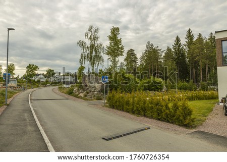View of speed bump on village street road. Landscape view background. Europe. Sweden.
