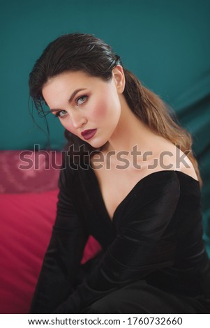 Portrait of beautiful young woman with makeup in black dress. 
Fashion photo