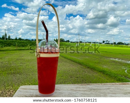 Lemon ice tea on the wooden table with beautiful nature background. Refreshing concept.