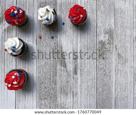 five red and white cupcakes, muffins, with decorative stars on a white textured wooden board, high quality photo, free space for text, background for the holiday of Independence Day USA, horizontal