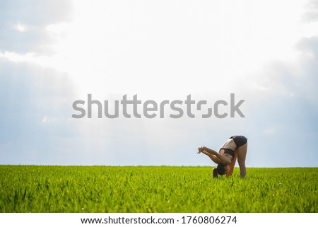Morning workout. Healthy lifestyle concept. Young attractive woman in sportswear makes stretching her hand before training on the nature at dawn. Muscle warming
